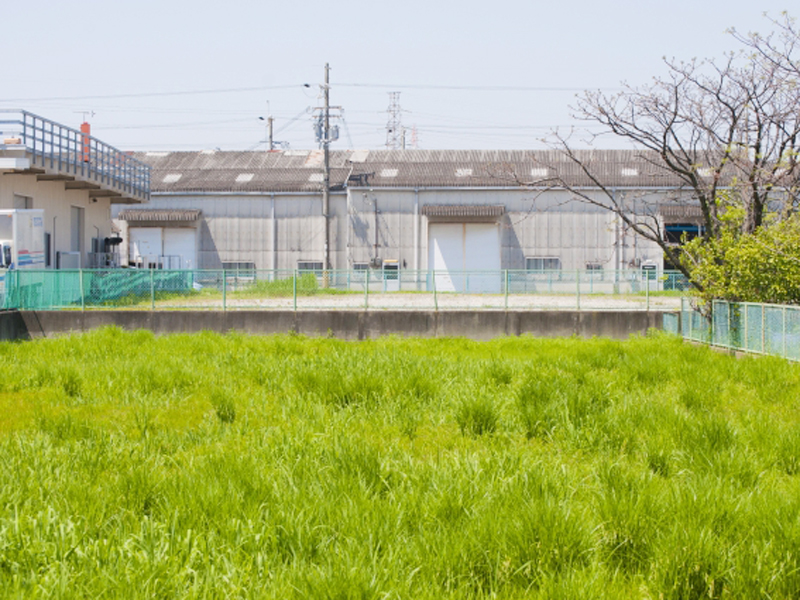 売地の写真。周りは工場に囲まれている。